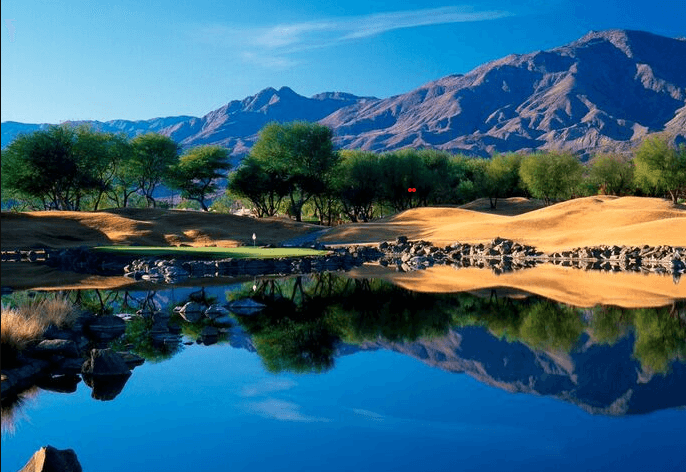 Scenic traditional golf course with water and mountain backdrop